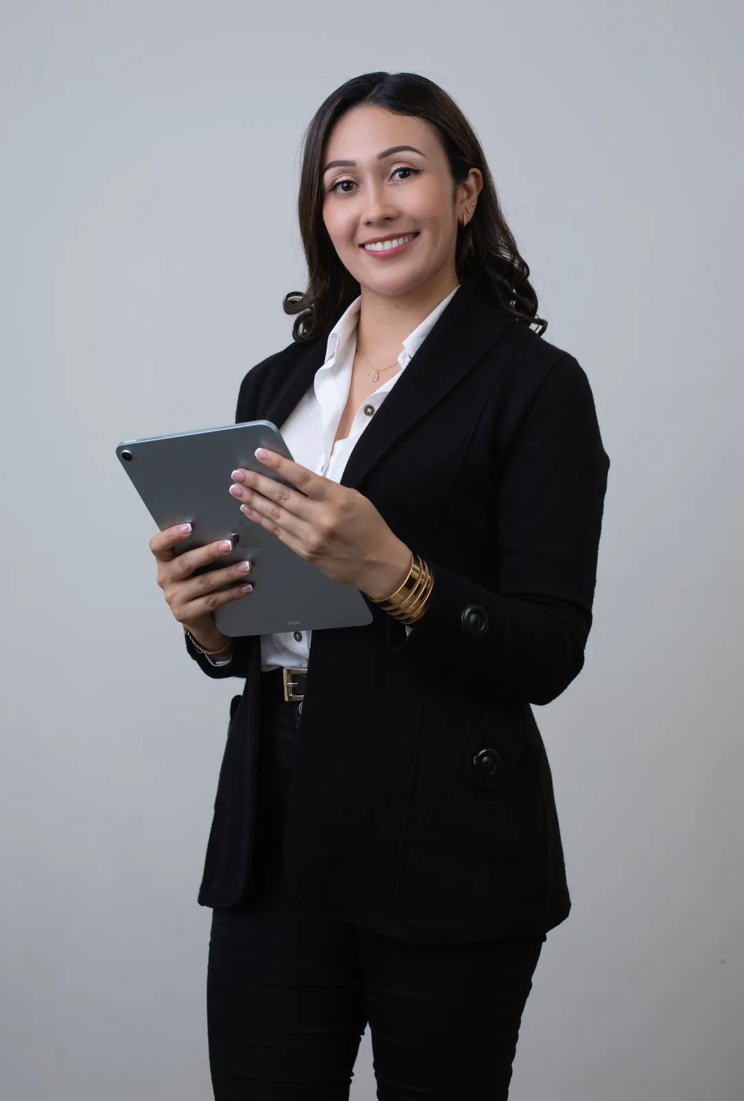 Retrato profesional con blazer negro sosteniendo una tablet