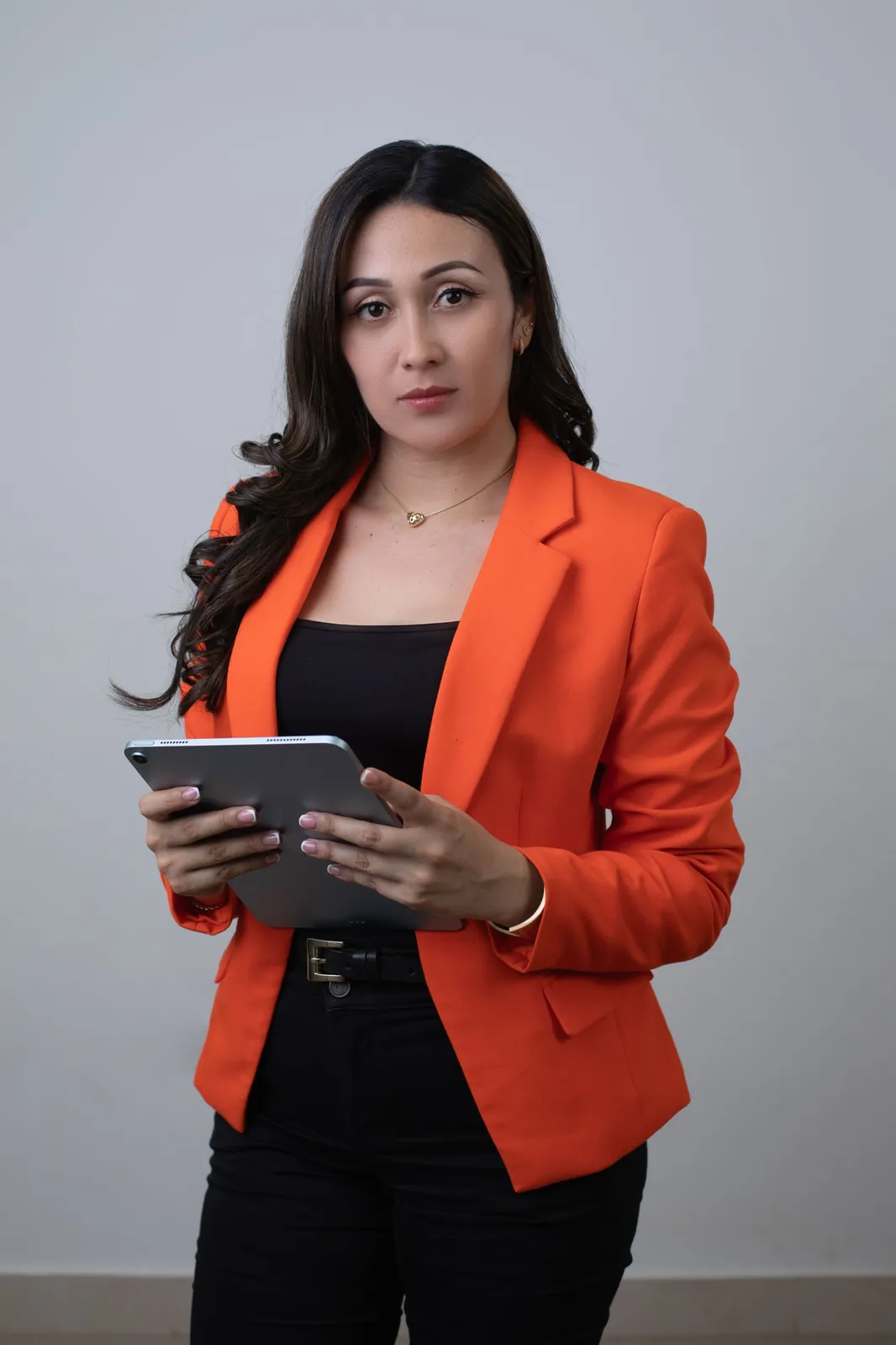 Retrato de emprendedora con blazer naranja y tablet