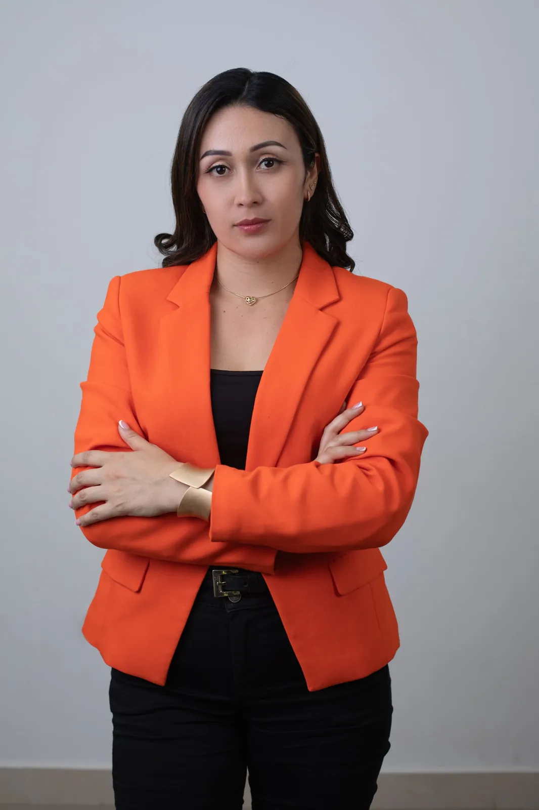 Retrato de marca personal con blazer naranja y brazos cruzados