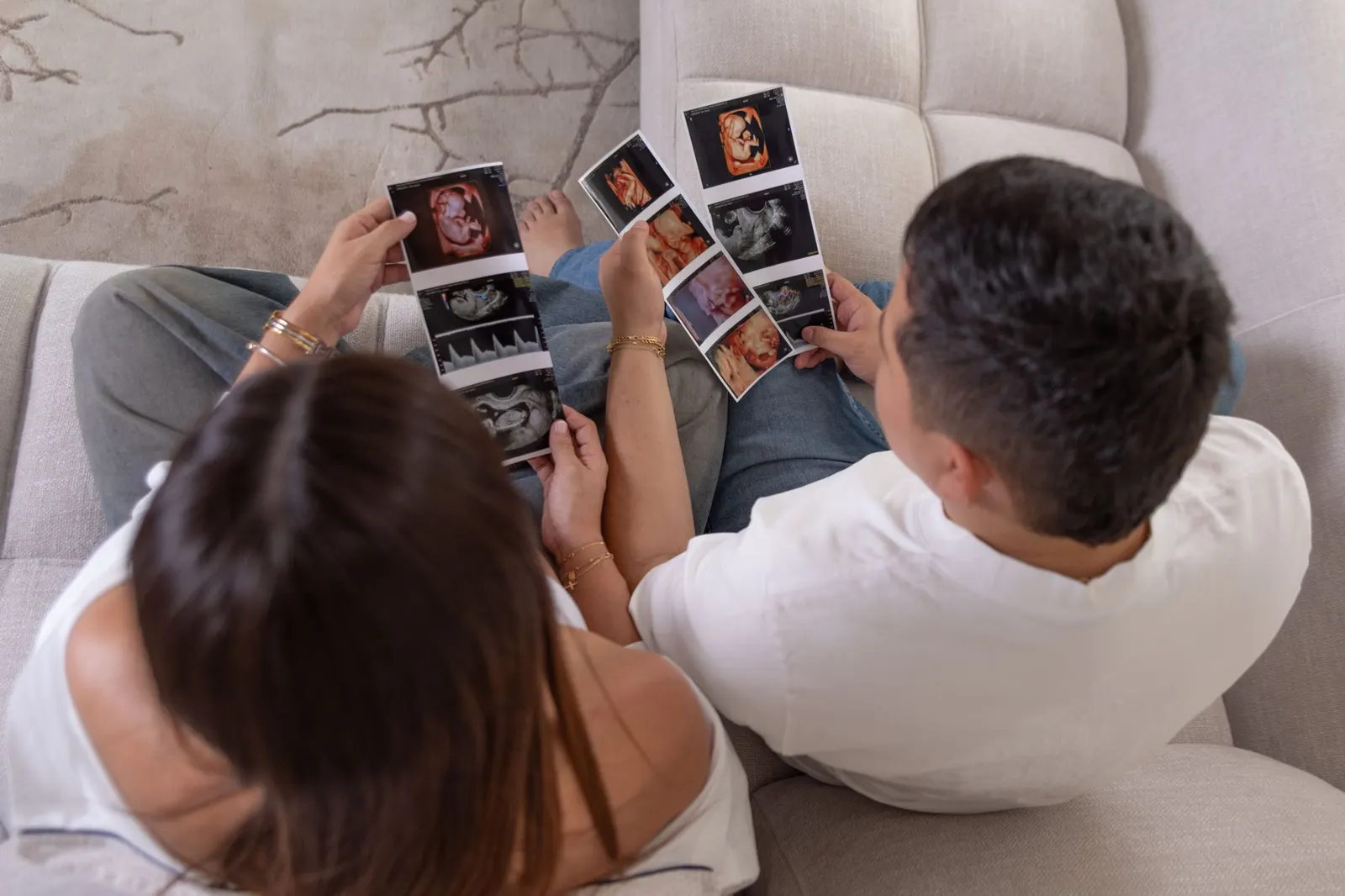 Pareja mirando las ecografías de su bebé desde arriba