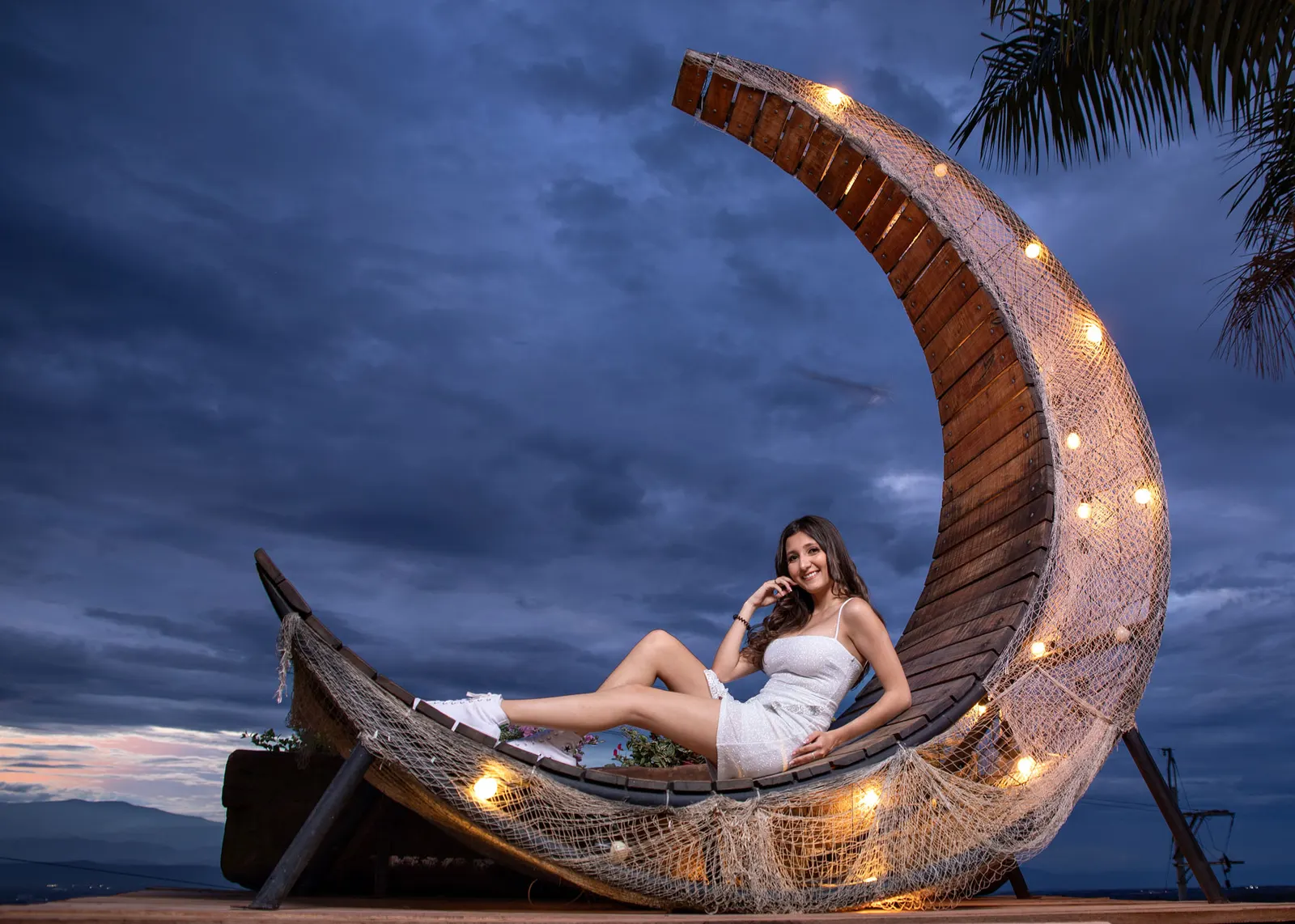 Sesión casual de quince años sobre una luna de madera con luces